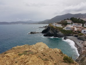 Vista panoràmica de Llançà amb costa rocosa, edificis i muntanyes al fons