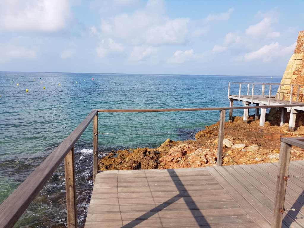 Passarel·la de fusta amb vistes al mar i roques a Salou