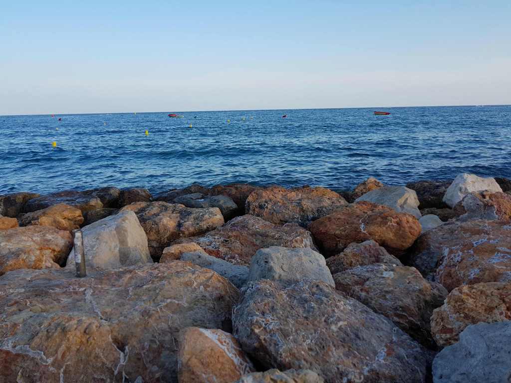 Vista des de les roques de Salou amb mar tranquil i barques a l’horitzó