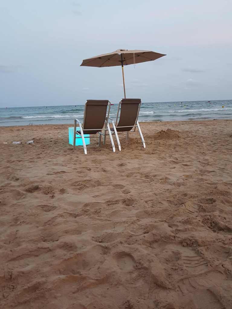 Dues hamaques sota un para-sol a la platja de Salou amb mar i cel ennuvolat
