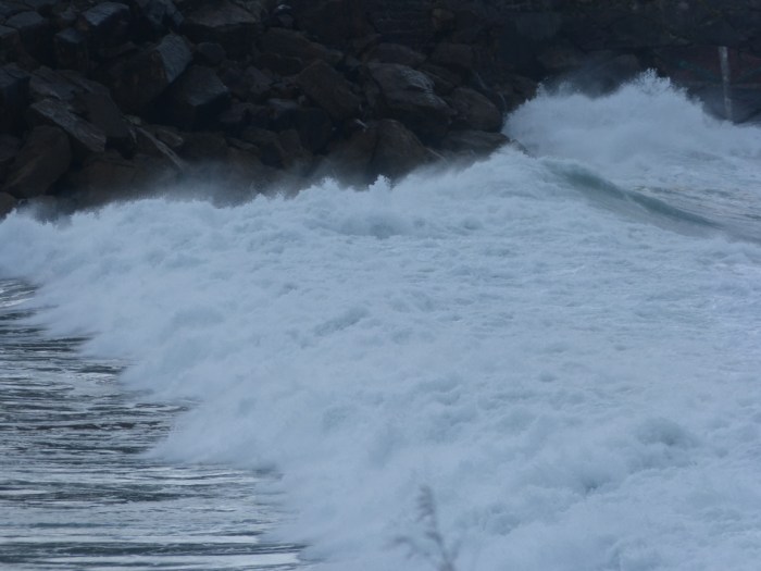 Onades trencant contra roques fosques amb escuma blanca al Mar Cantàbric