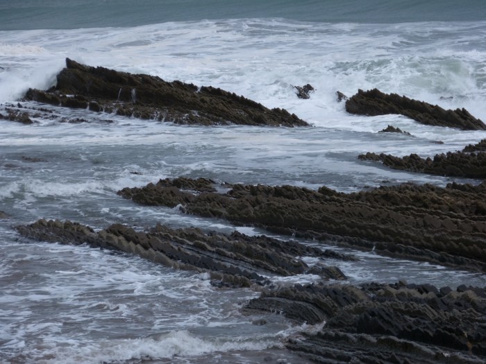 Onades trencant contra roques escarpades amb escuma blanca al Mar Cantàbric