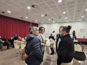 Grup de persones conversant a la sala de la biblioteca