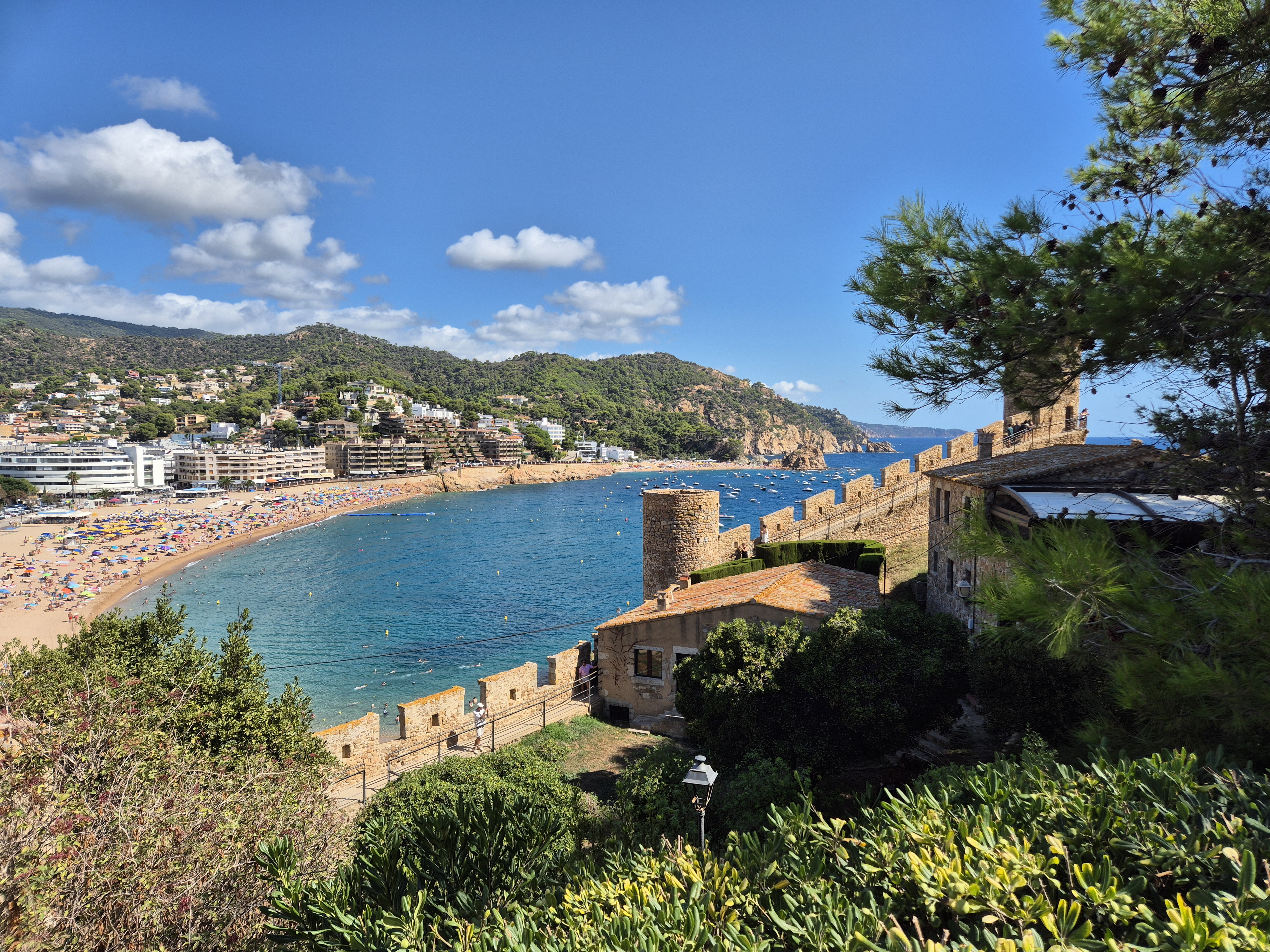 Vista de la muralla medieval de Tossa de Mar amb la platja i el poble al fons